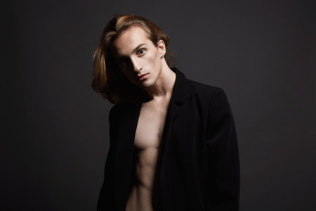 Boy with long hair. Young man with trendy hairstyle. Studio Portraitの写真素材