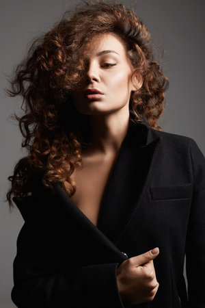 Fashion portrait of Beautiful young woman. sexy beautiful girl with make-up and curly Hairの写真素材