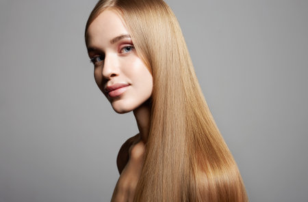 beautiful blond hair young woman. beauty portrait of smiling girl with smooth wheat colored hairの写真素材