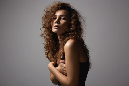 sensual beautiful young woman with curly hair. portrait of pretty girl in underwearの写真素材