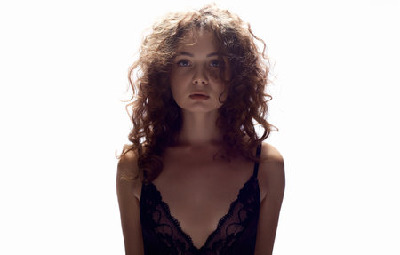 beautiful young woman with curly hair. isolated portrait of pretty brunette girl in undewearの写真素材