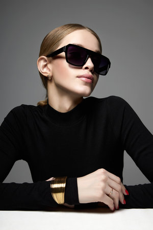 fashion portrait of Beautiful young woman in sunglasses. blonde girl in glasses and braceletの写真素材