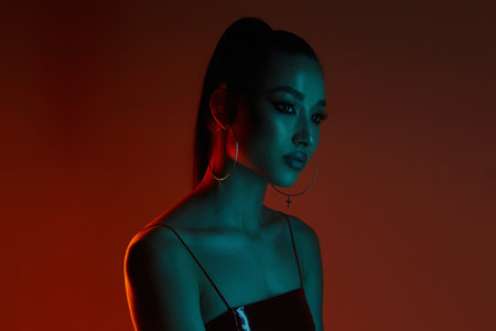 beautiful young woman in color lights. Brunette girl in red studio portraitの写真素材