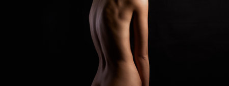 Nude Woman part silhouette. Back of Beautiful Naked Body Girl in Darkの写真素材
