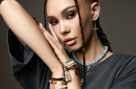 beautiful girl with braids and many bijouterie accessories. pretty young brunette woman with tressed hairstyle. hip-hop styleの写真素材