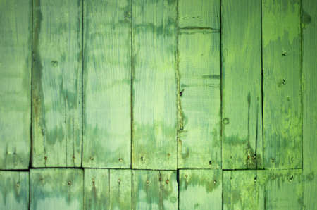 Old green painted and stained wooden planks with nail heads background textureの写真素材