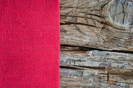 Red cloth on a coarse wooden background with copy space. Seasons greeting card design concept.の写真素材