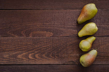 Ripe pears on rustic dark wooden table with copy spaceの写真素材