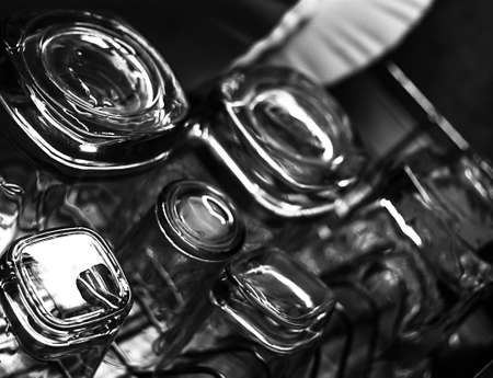 Black and white close-up image of whiskey Old Fashioned or Rocks glasses along with shot or shooter glasses on a dish drainer in the kitchenの写真素材