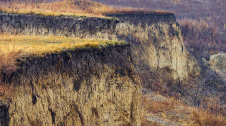 Weathered canyon rims with yellow grass on a late autumn dayの写真素材