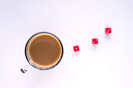 Taking chances concept. A glass mug of coffee and dice, isolated white background, top view.の写真素材