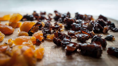 Healthy Diet Food Ingredients: Chopped Dried Apricots And Prunes On A Wooden Cutting Board.の写真素材