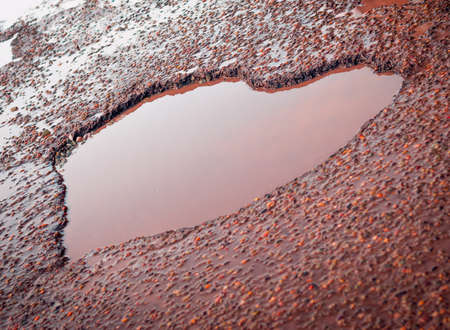 Heart Shaped Pothole In The Old Asphalt Road With Puddles, Gravel, Stones. Love Sign