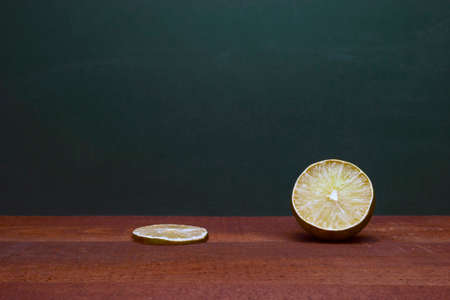 Cross Section Of A Lime And A Lime Slice On A Wooden Table. Green Background. Organic Accent To The Flavors Of Foods And Beverages.の写真素材