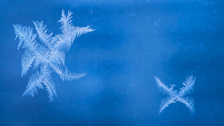 Winter Holidays Season Fantasy World Concept: Macro Image of Natural Ice Crystals Patterns on a Blue...