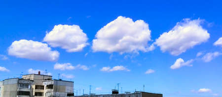 Scenic Clouds on Deep Blue Sky Background over Rustic Apartment Building of Concrete Panels on a...