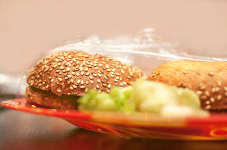 A Burger, Lettuce on Red Plate in a Plastic Wrapper. Takeaway, Food Storage Ideas.