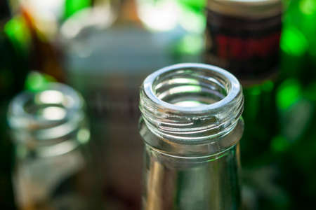 Glass Bottle Neck and Finish known as Small Mouth External Thread, Screw Threads,  Screw-Top, Screw-Cap, Helix, Coil, Duplex and External Screw Thread. Blurred Glass Bottles Background.の写真素材