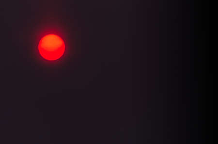 Close-Up of Red Sun Circle In Hazy City Air. Pollution, Climate Change Concept.の写真素材