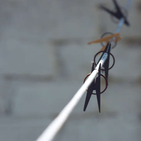 Plastic Clothespins on White and Blue Clothes Line On Blurred Background.の写真素材