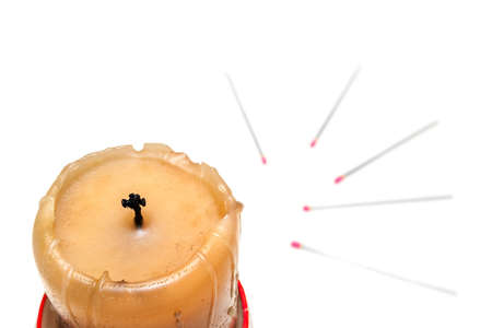 Burnt Golden Candle With Cross Like Black Wick. Blurred Pink Head Matches in Background.の写真素材