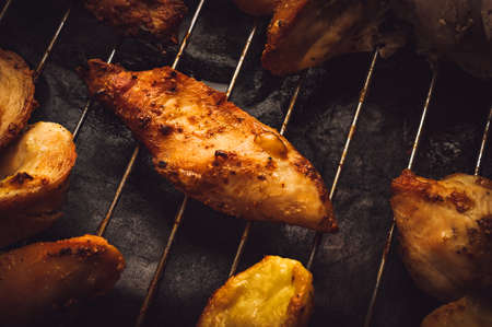 Roasted Chicken Slices and Potatoes on Stainless Steel Cooking Grid. Grilled Chicken Breast with Slices Made for Marinade to Penetrate the Meat Better, and Ensure Chicken Cooked Evenly.の写真素材