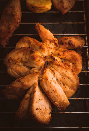 Grilled Chicken Breast with Slices Made for Marinade to Penetrate the Meat Better, and Ensure Chicken Cooked Evenly. Roasted Potatoes and Chicken Slices on Stainless Steel Cooking Grid.の写真素材
