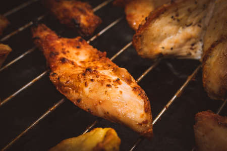 Roasted Chicken Slices and Potatoes on Stainless Steel Cooking Grid. Grilled Chicken Breast with Slices Made for Marinade to Penetrate the Meat Better, and Ensure Chicken Cooked Evenly.の写真素材