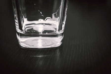 Square Bottom of Empty Beer Glass on Dark Table Surface. Bubbles Left from the Beer Head or Collar, Frothy Foam on Top of the Glass.の写真素材