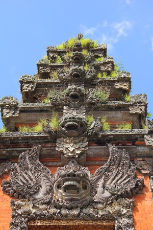 Balinese sculptures repeated on multiple tiers above a doorway  Vertical view の写真素材
