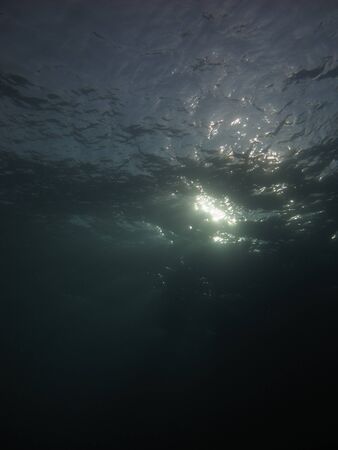 A setting sun's rays captured underwaterの写真素材