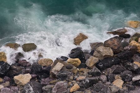Waves crashing on a rocky beach in Vernazza, Cinque Terreの写真素材