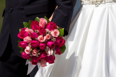 Bride and groom holding bridal bouquetの写真素材