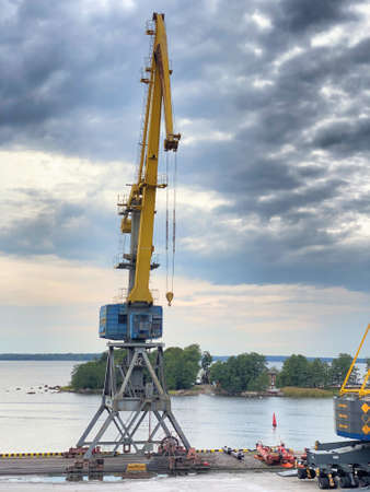 Yellow arrow of a harbor crane. Photo in the sky, equipment in the seaport. City landscape, shipbuilding.の写真素材
