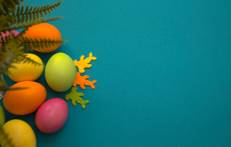 Colorful Easter eggs. Banner, wallpaper, postcard, social media post with copy space for text. Painted eggs arranged on one side on a blue backgroundの写真素材