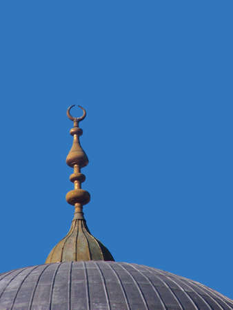 Crescent moon on top of a mosque in Istanbul with bright blue sky backgroundの写真素材