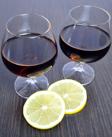 two glasses of cognac with lemon and a burning candle
