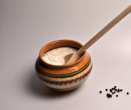 Croup for cooking porridge in a clay plate and a wooden spoonの写真素材