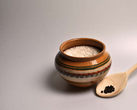 Croup for cooking porridge in a clay plate and a wooden spoonの写真素材