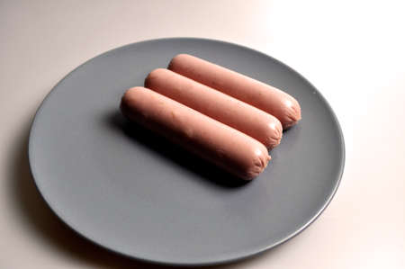 food - three sausages on a gray plate with vegetablesの写真素材