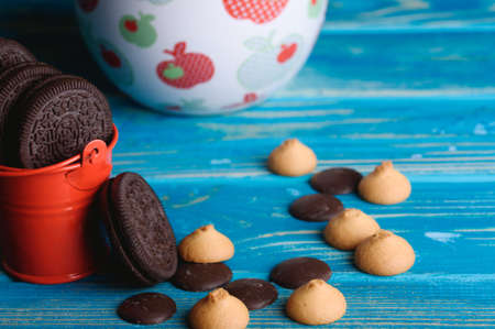 A small red bucket with chocolate cookies on the tableの写真素材