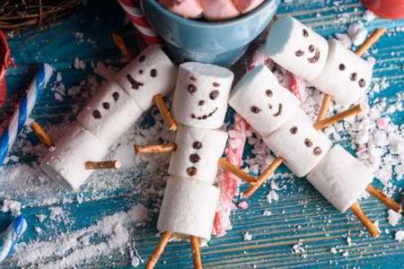 Snowmen from marshmallows. New year snowmen. A festive table made of tea and sweet snowmen.の写真素材