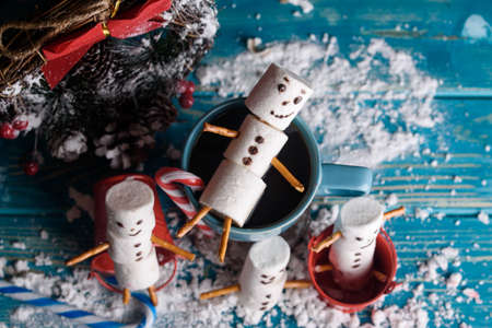 Snowmen from marshmallows. New year snowmen. A festive table made of tea and sweet snowmen.の写真素材