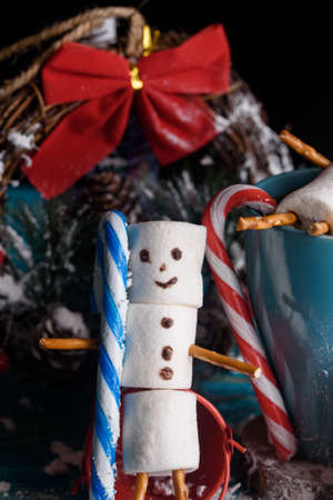 Snowmen from marshmallows. New year snowmen. A festive table made of tea and sweet snowmen.の写真素材