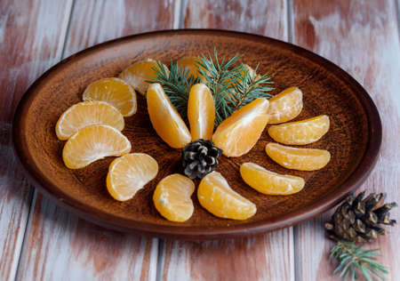 Chilled mandarin on a table with sprigs of spruce