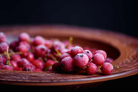 Frozen red currant  in a decorated plate on the table