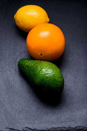 Three ripe fruits on a slate boardの写真素材