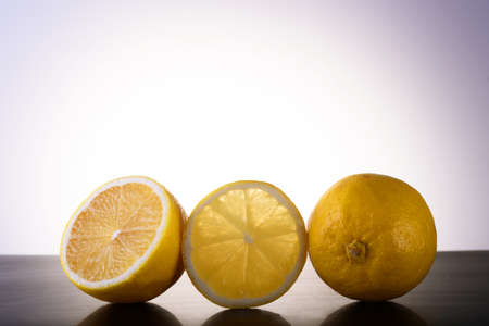 Photo of illuminated lemons with reflection on dark background. Three isolated yellow lemons on...