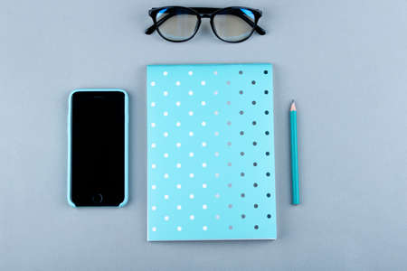 Phone, glasses, pencil, notebook on the background.の写真素材