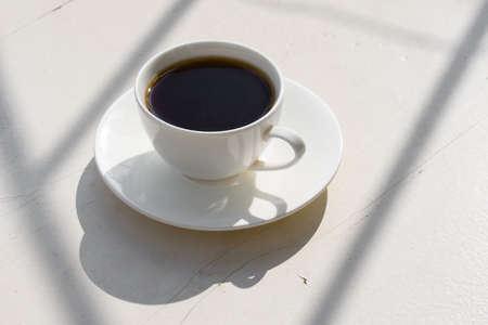 Fragrant coffee in a white cup on the nature. Natural lighting.